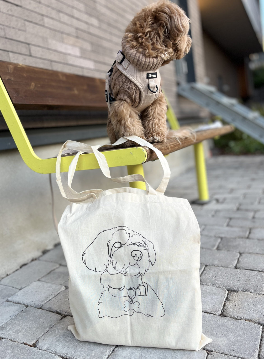 Small dog standing on a tote bag with a dog illustration, placed on a bench.

Tote Your Pet – Custom Pet Tote Bag (Line Art)	Ta Med Ditt Husdjur – Personlig Tygkasse (Linjekonst)